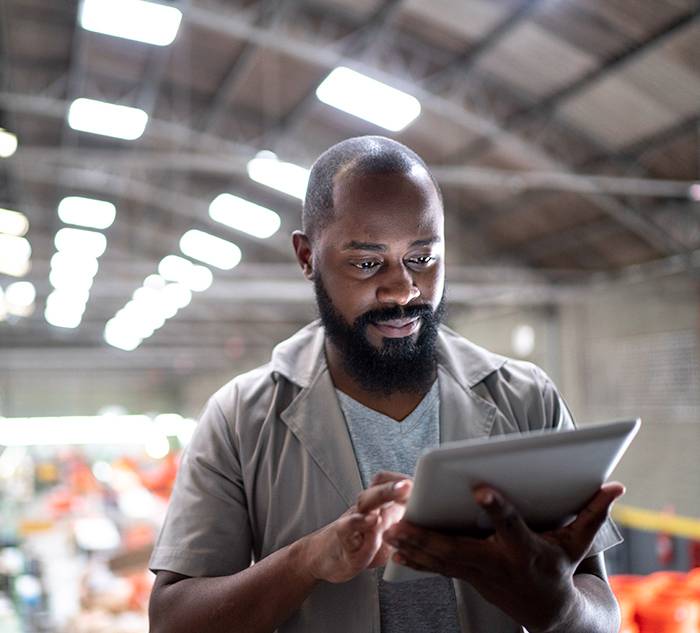 Focused manager using digital tablet in a factory