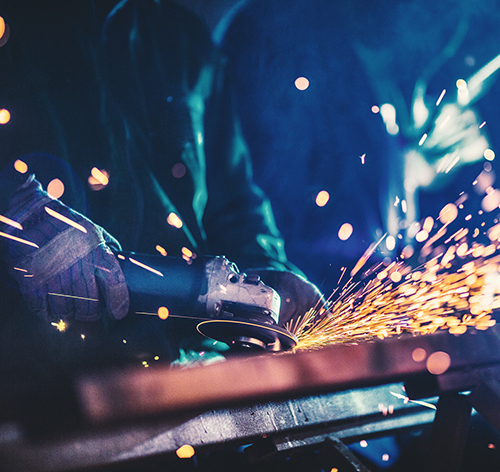 metal welder generating sparks with work gloves on