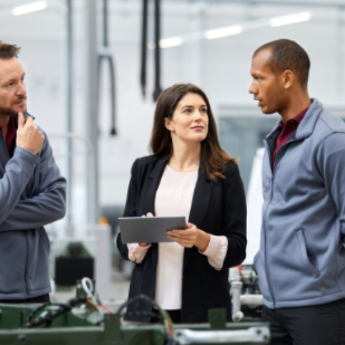 Three people looking at an ipad and talking