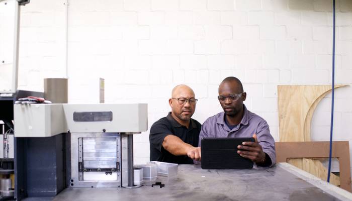 2 manufacturing worker working on a tablet Genius partners with Nuage